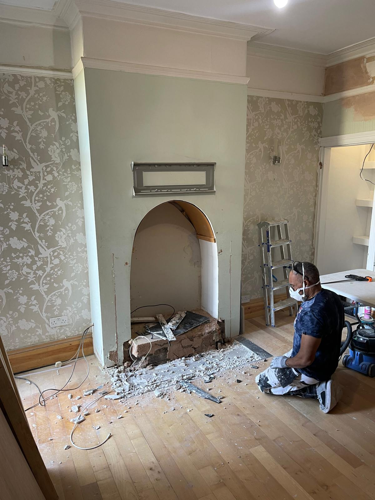 Original fireplace wall during careful demolition and preparation