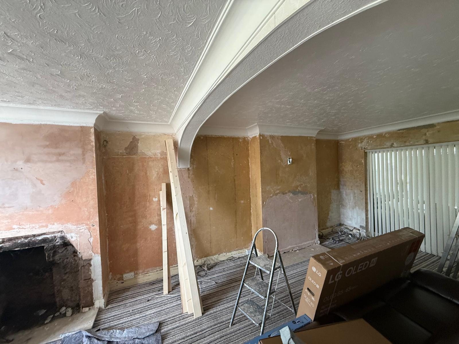 Lounge archway and walls stripped back to bare plaster before rebuild