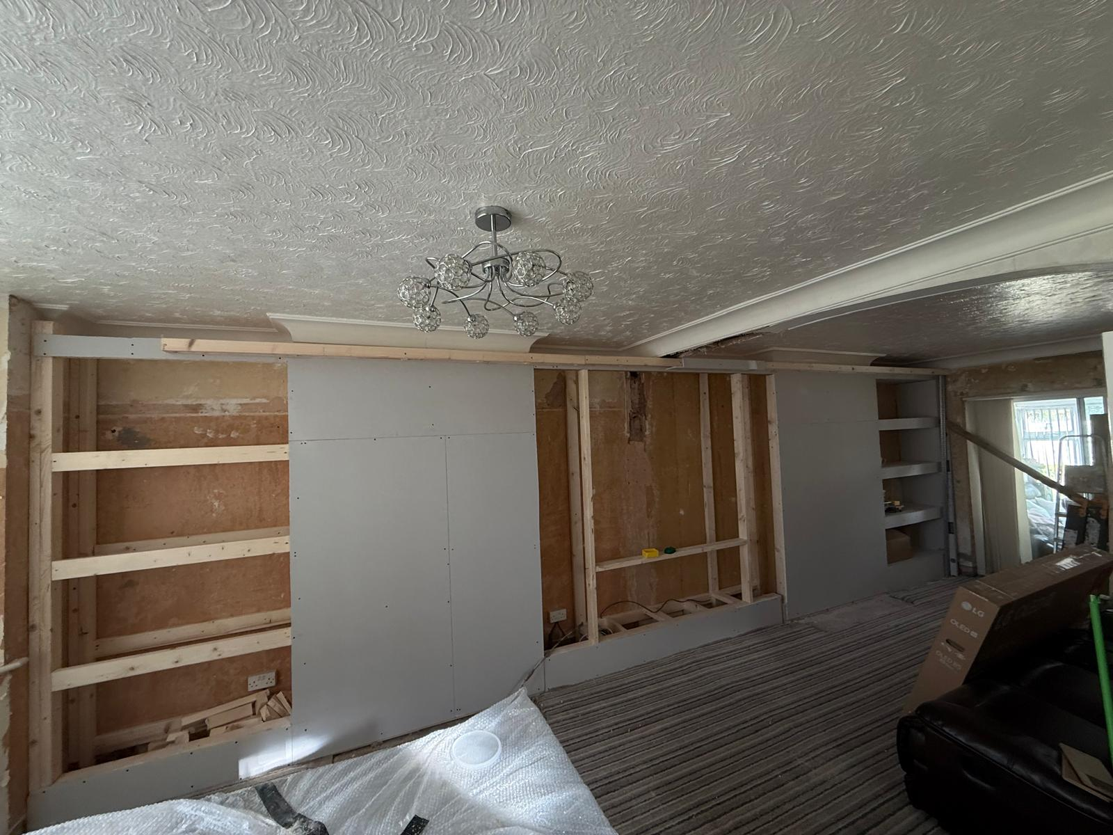 Lounge media wall being boarded with recessed shelving formed