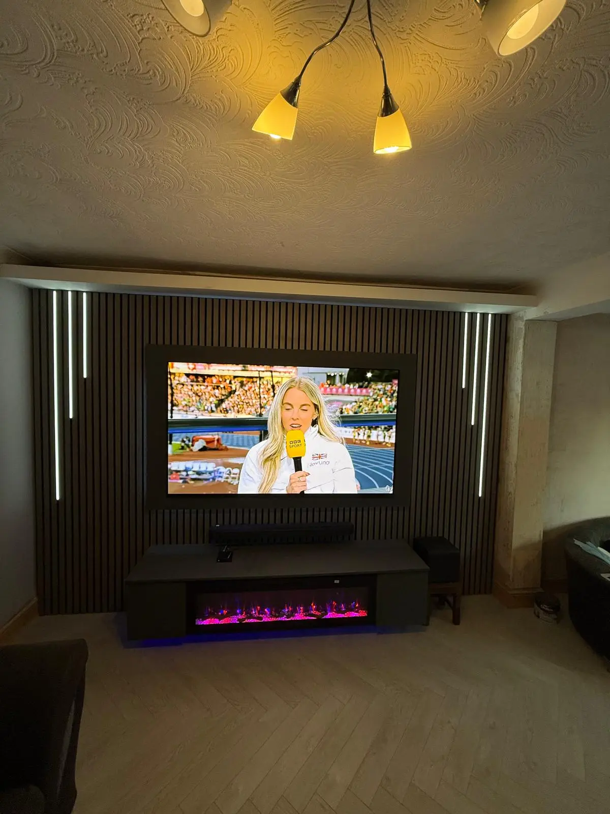 Completed slat media wall with floating unit and electric fire