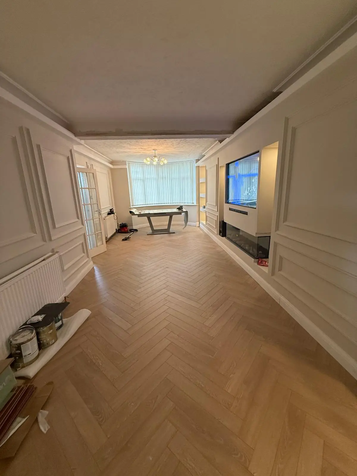 Finished lounge with wall panelling, herringbone floor and media wall fireplace