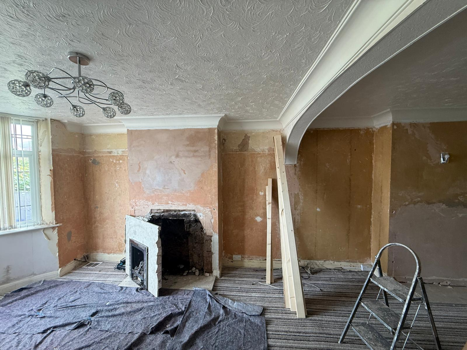 Original fireplace being removed with floors protected by dust sheets