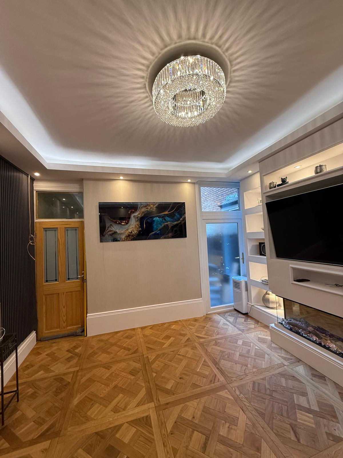 Finished room with crystal ceiling light and refined wall detailing