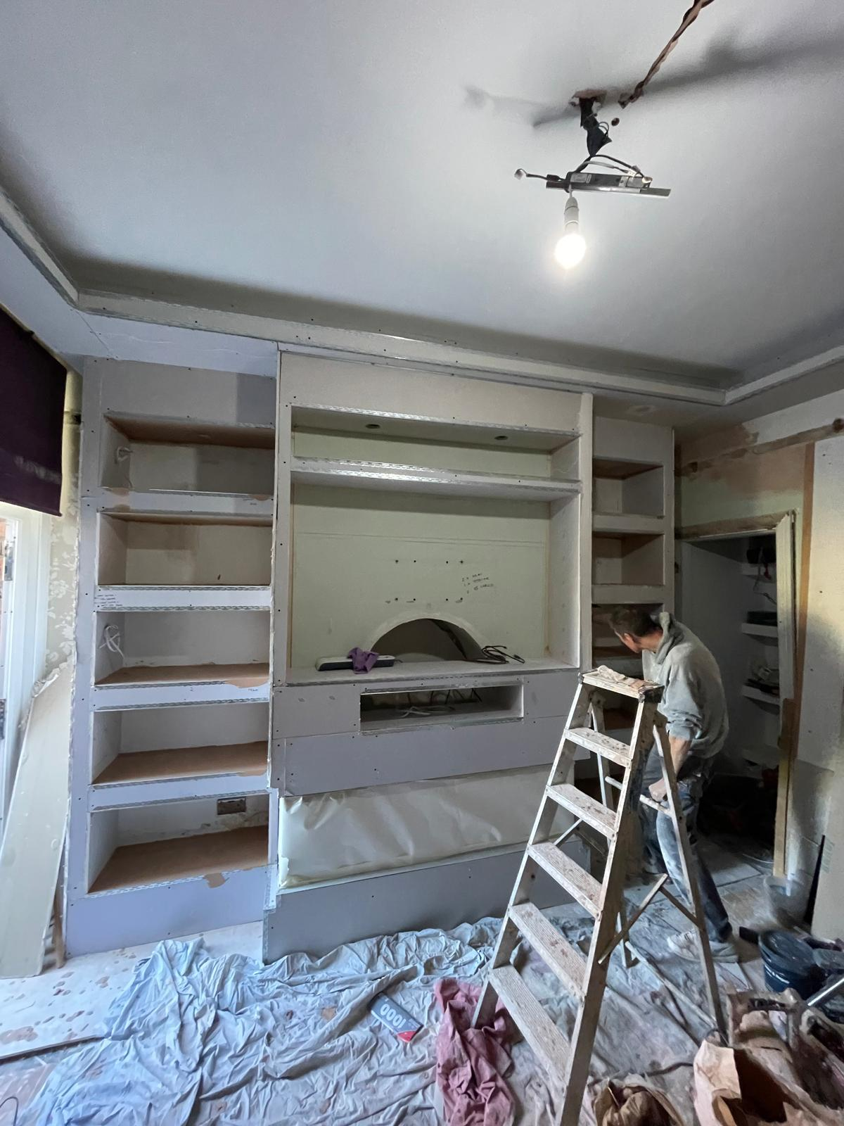 Bespoke media wall after plastering with shelving and recesses formed