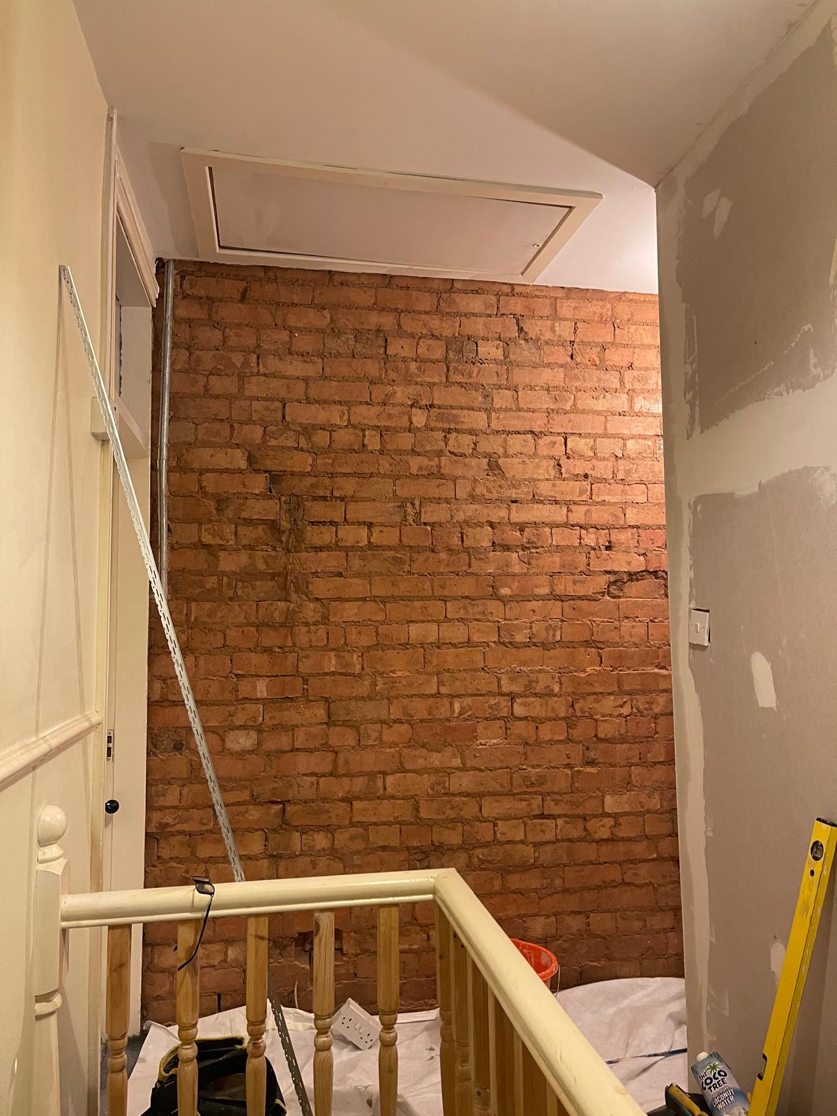 Stair landing with exposed brick wall during renovation works